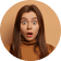 Surprised woman with brown hair against a neutral background